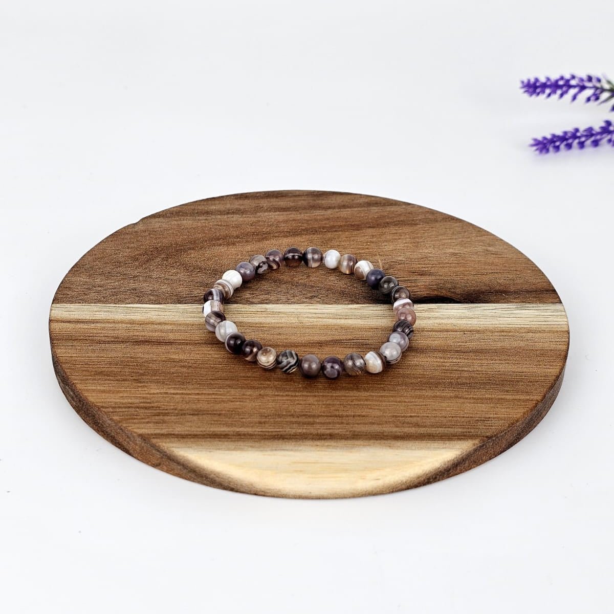 Beaded botswana agate bracelet on a wooden coaster with a white background