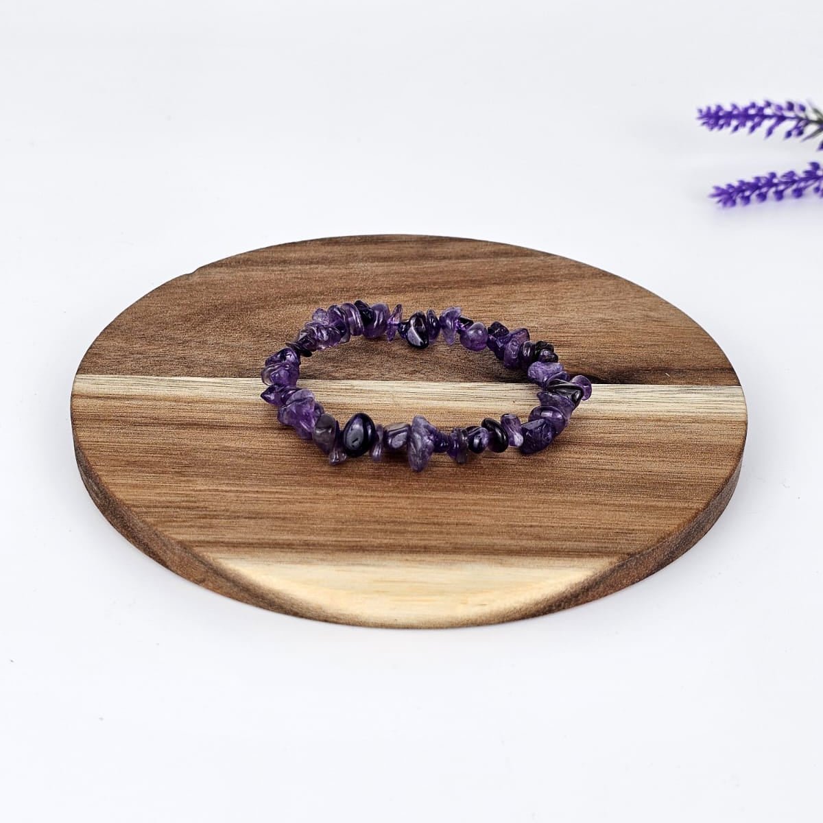 Amethist chip bracelet on a wooden plate and white background