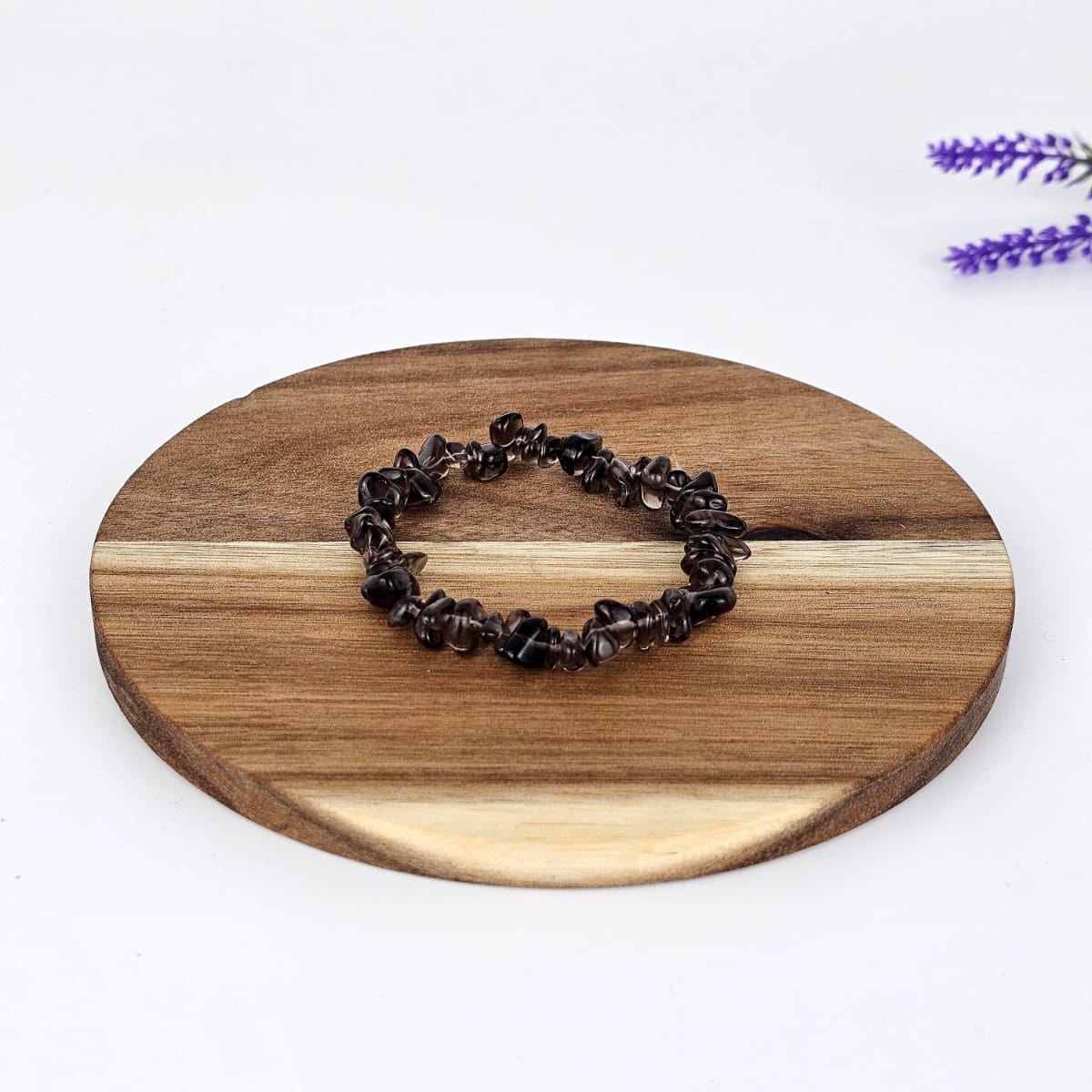 smoky quartz chip bracelet on a wooden plate and a white background