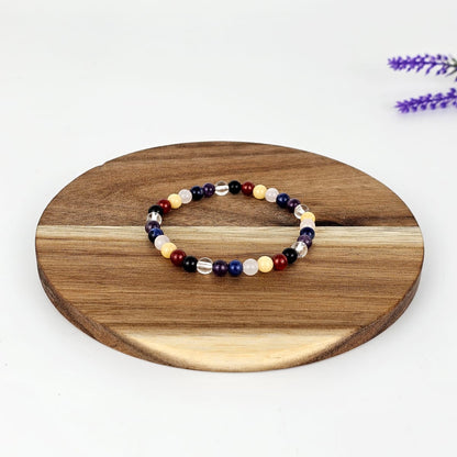 Beaded chakra bracelet on a wooden round platform with a white background