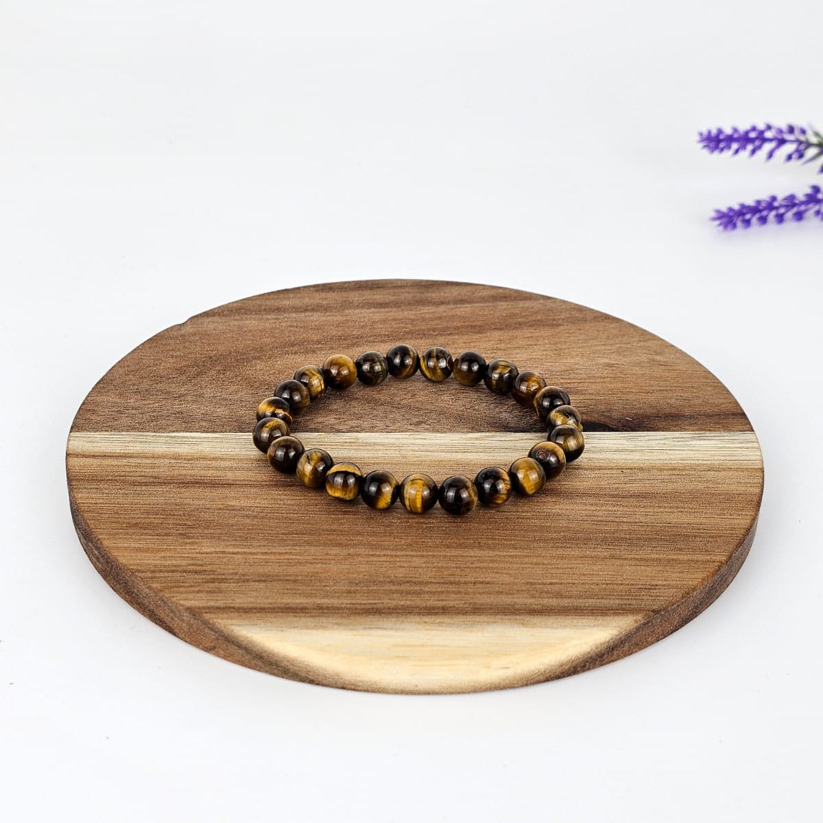 Beaded tiger's eye bracelet on a wooden plate with a white background