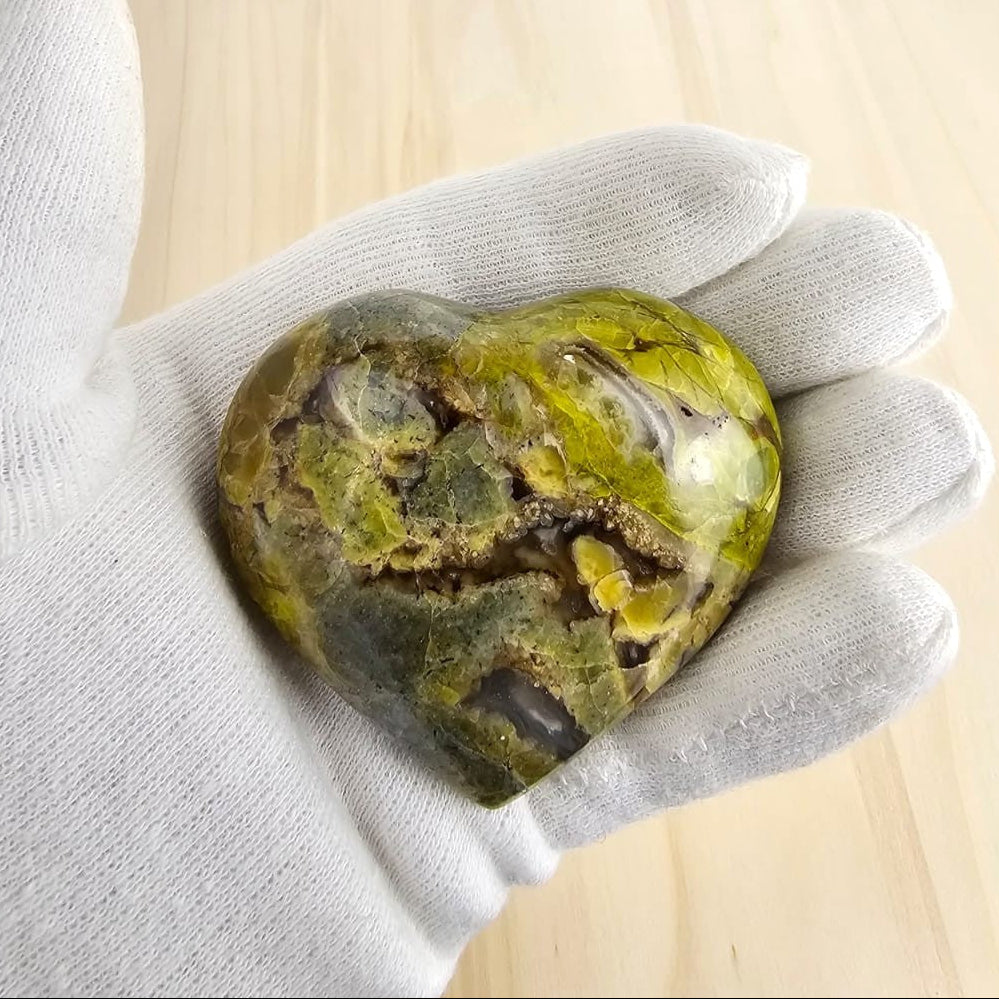 Green opal crystal in gloved hand