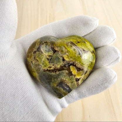 Green opal crystal in gloved hand