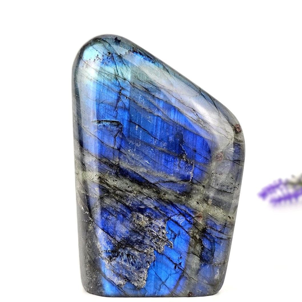 Polished labradorite stone with blue and gray patterns on a white background