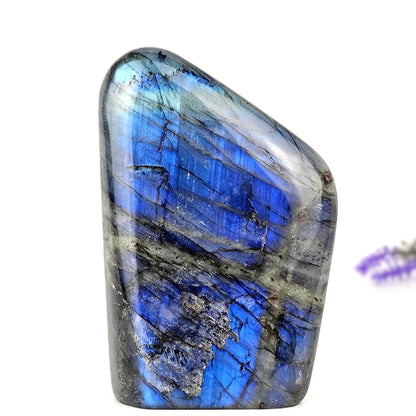 Polished labradorite stone with blue and gray patterns on a white background