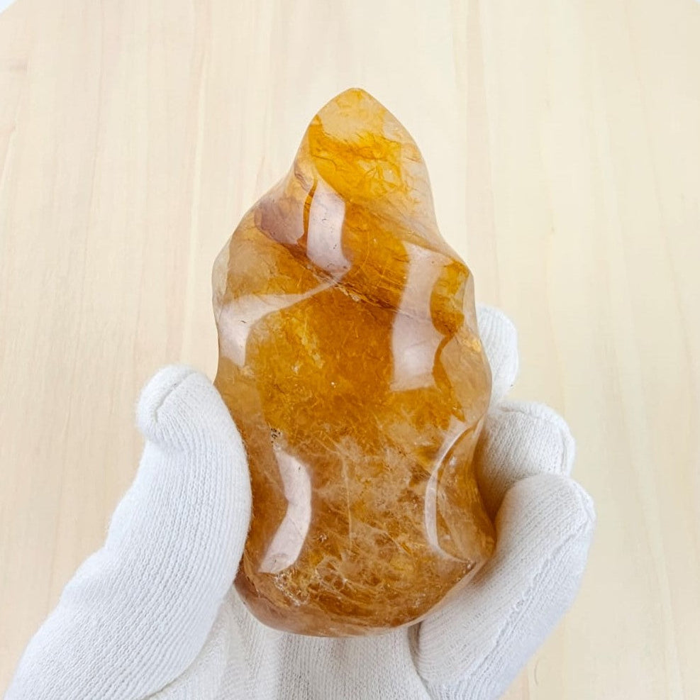 Hand holding a golden healer stone against a light background