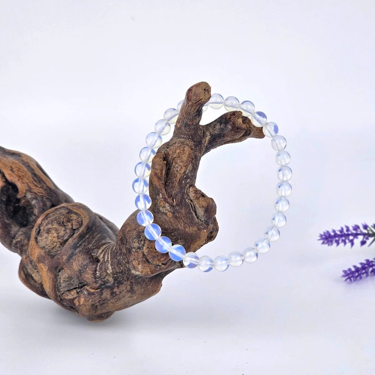 Clear beaded opalite bracelet on a piece of wood with a white background