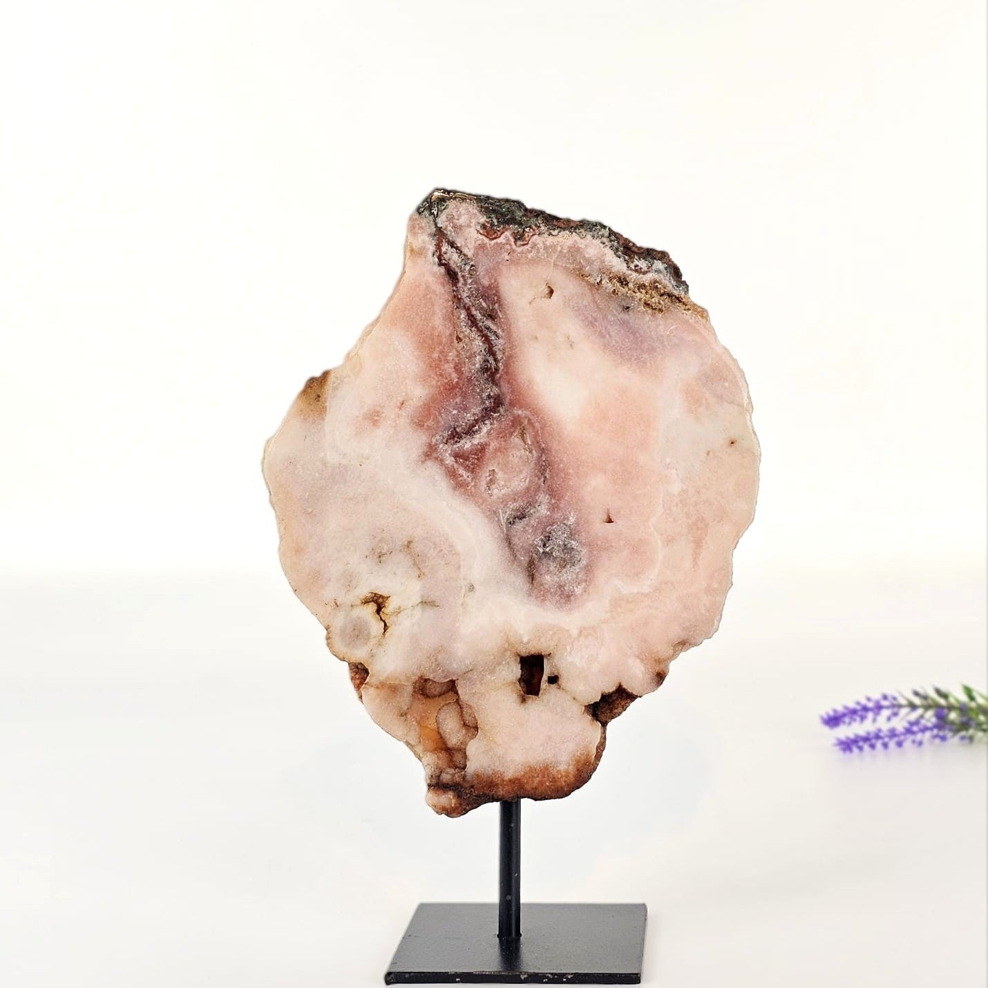pink amethyst on a stand with a white background