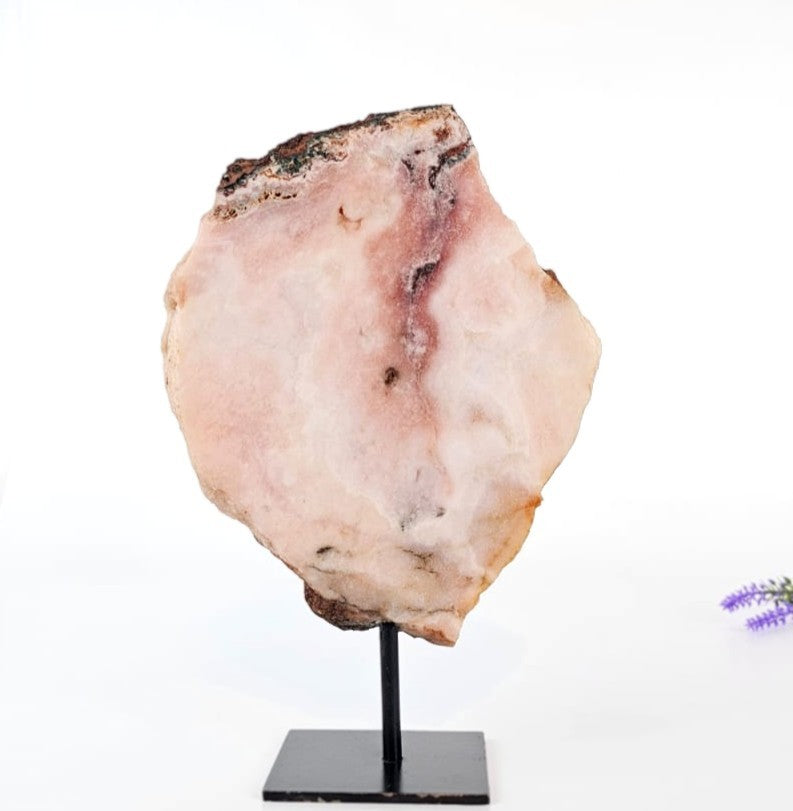 pink amethyst stone on a stand with a white background
