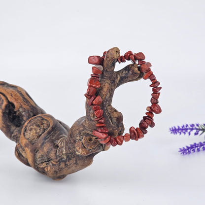 Red jasper chip bracelet on a wooden branche and white background
