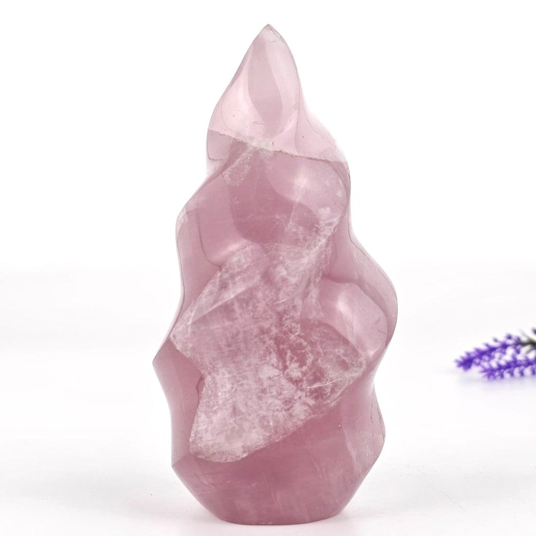 Rose quartz flame sculpture on a white background