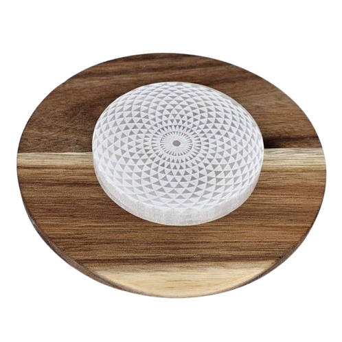 selenite stone with geometric pattern on a wooden round platform