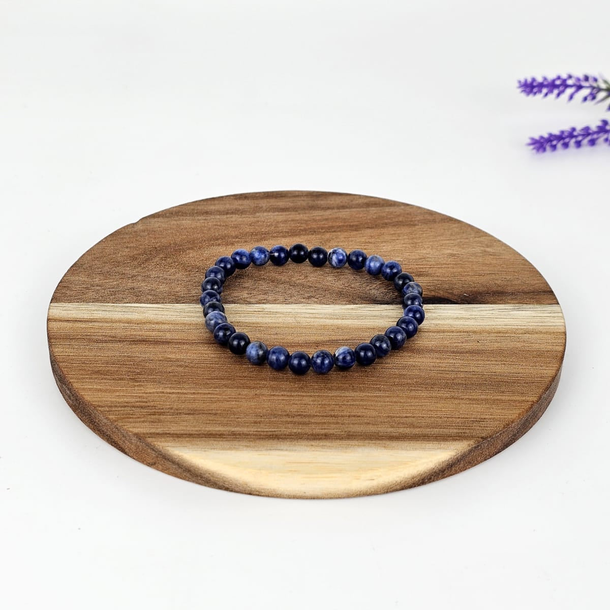 Beaded sodalite bracelet on a wooden plate and a white background