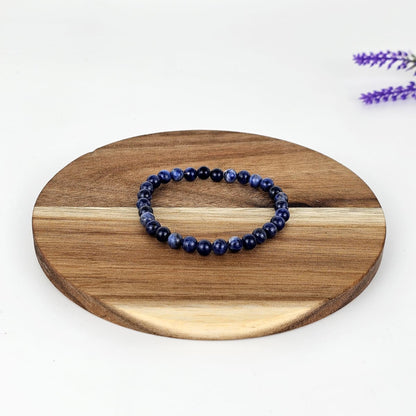 Beaded sodalite bracelet on a wooden plate and a white background