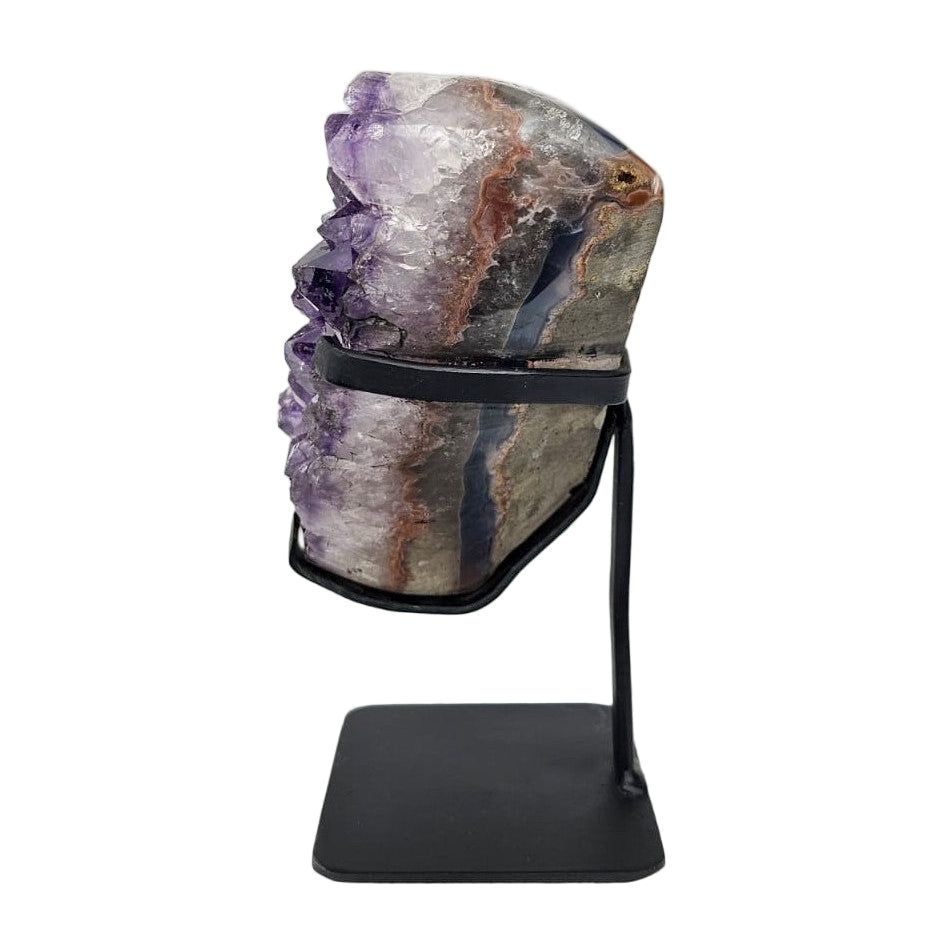 Amethyst crystal on a stand against a white background