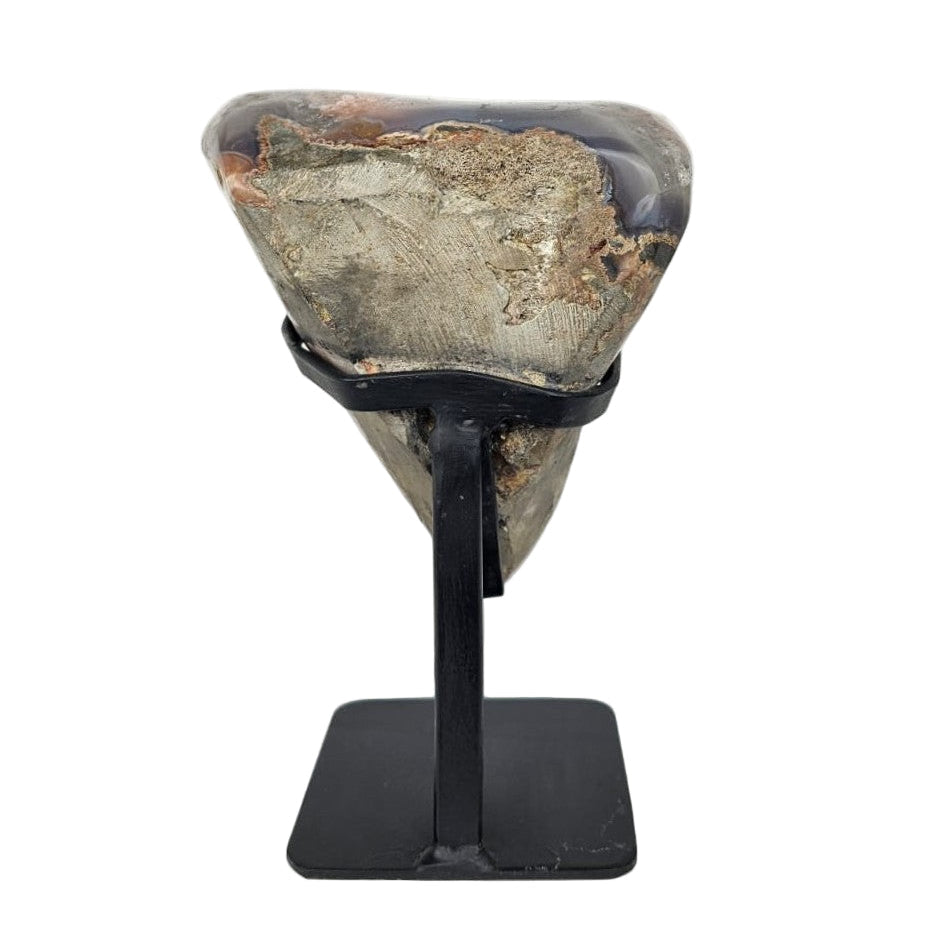 Back of a amethist cluster on a black stand against a white background