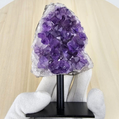 amethist cluster on stand in a gloved hand 