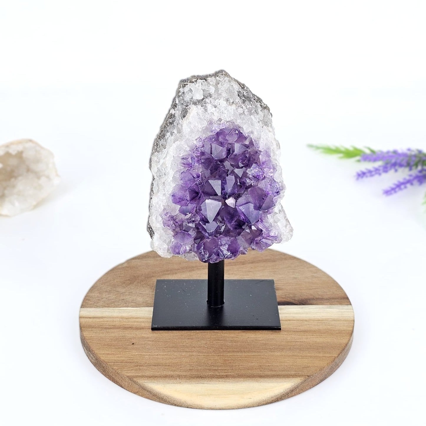 amethyst cluster on stand on a wooden board and white background