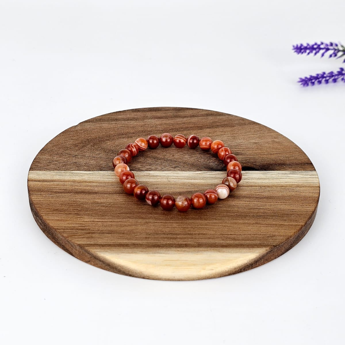 carnelian beaded bracelet on a wooden plate and white background