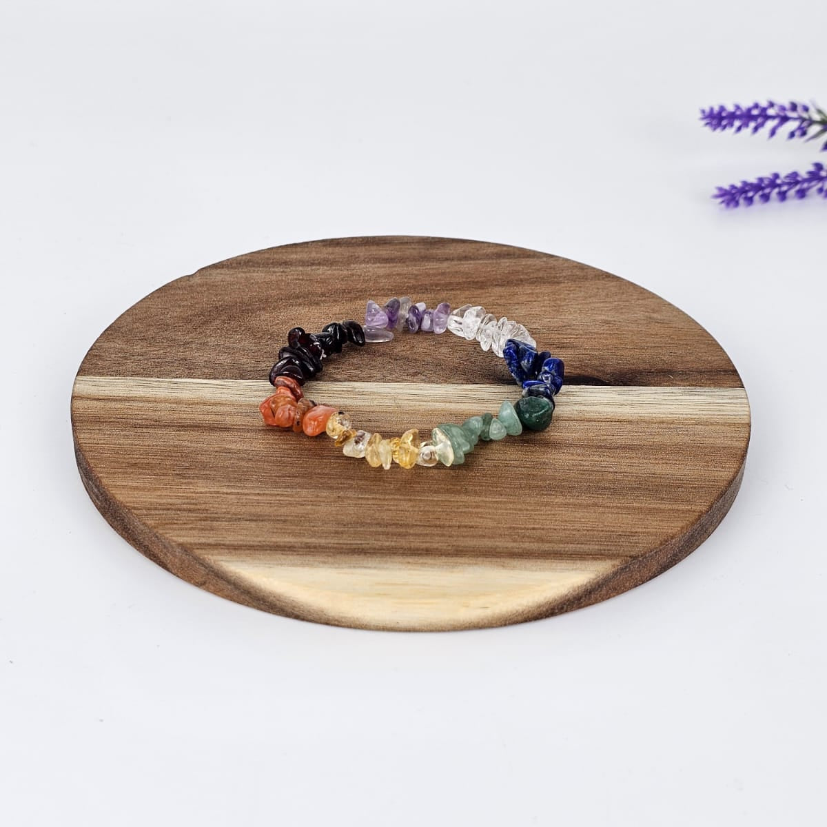 chakra chip bracelet on a wooden plate and a white background