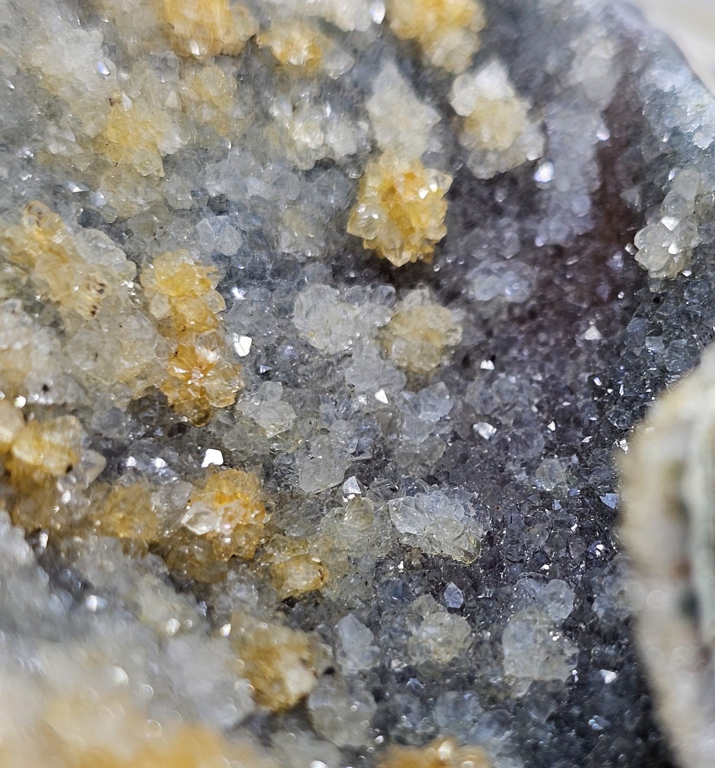 Close-up of mineral crystals with a mix of yellow, gray, and white colors.