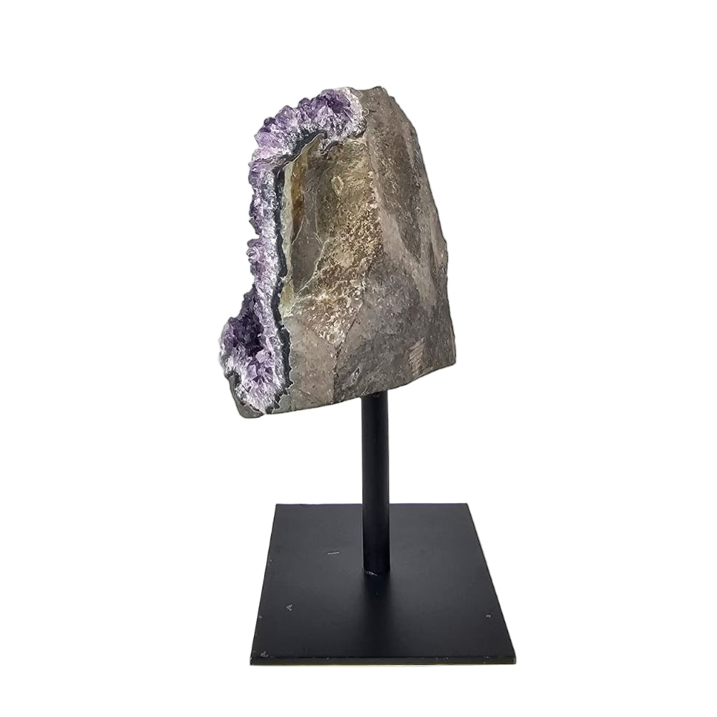 Amethyst geode on a black stand against a white background