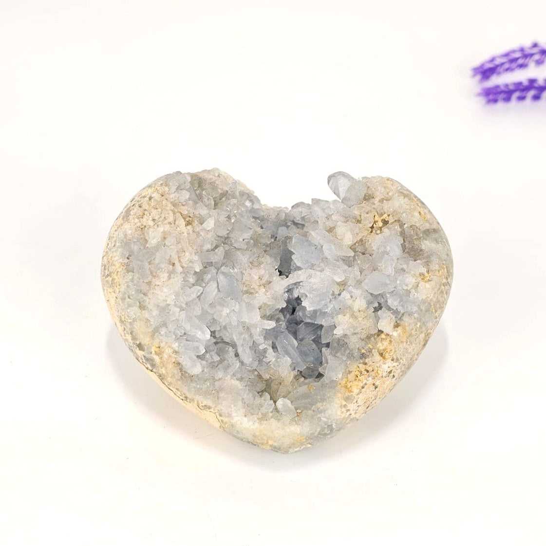 Heart-shaped celestite crystal cluster on a white background