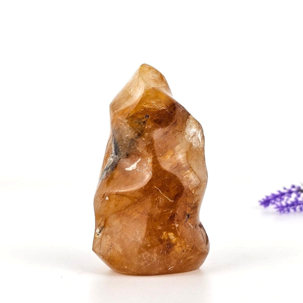 Golden healer flame sculpture on a white background