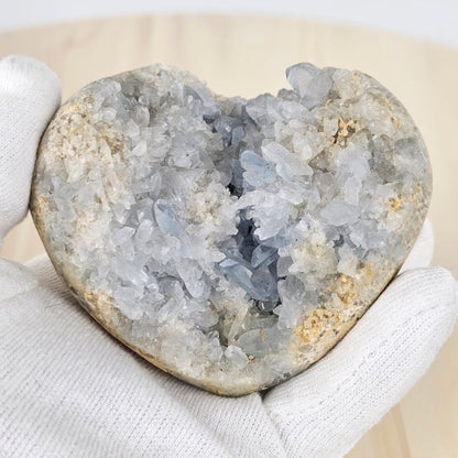 Celestite heart shape cluster in gloved hand