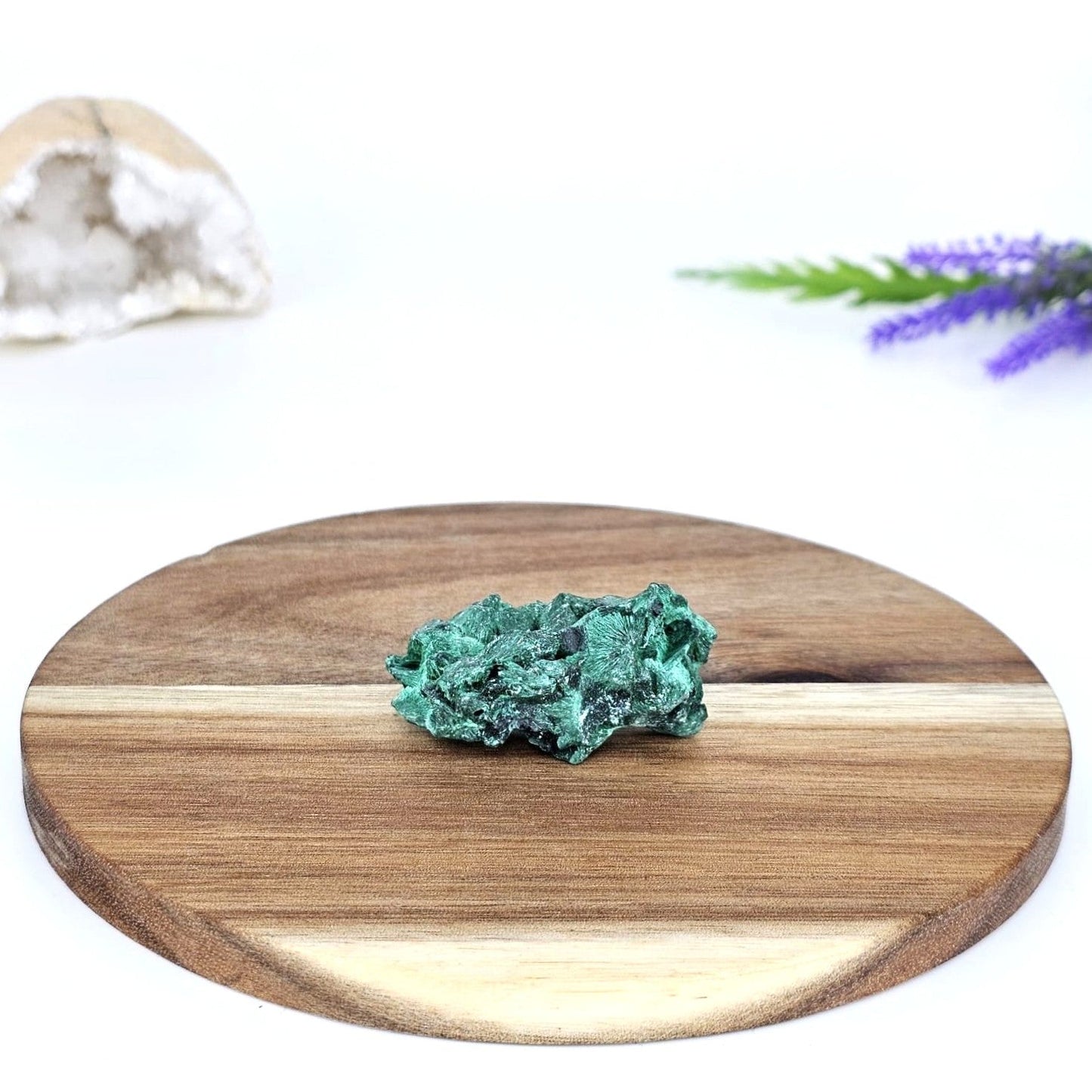 Raw malachite fibrous on a wooden plate and a white background