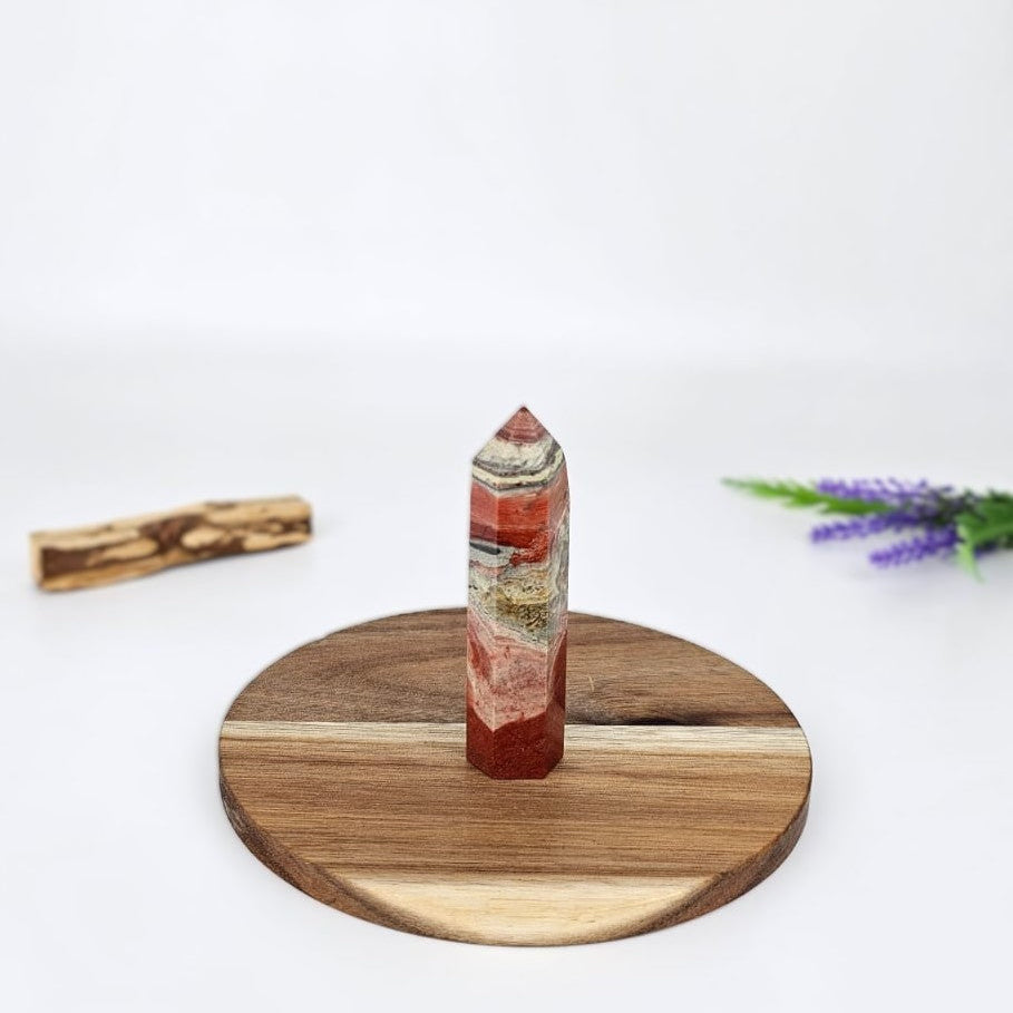 Red jasper tower on a wooden plate and white backgrounf