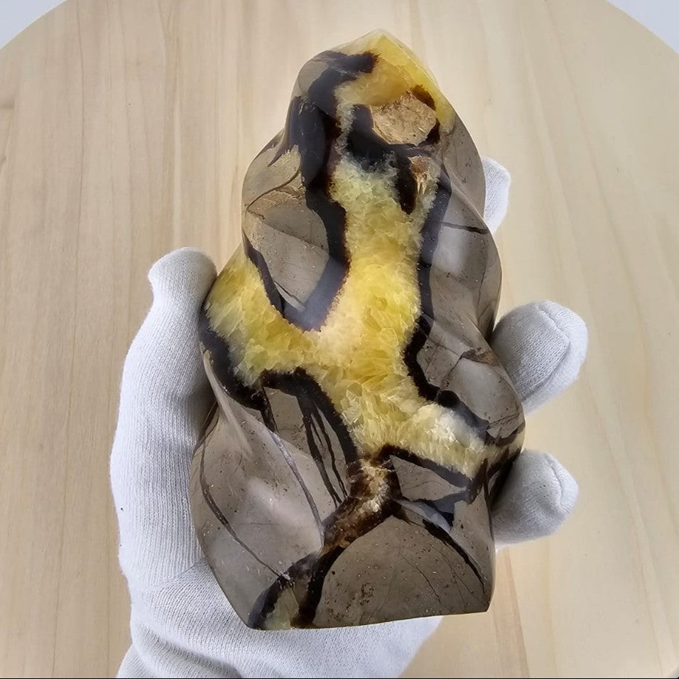 Septarian flame sculpture in gloved hand