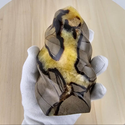 Septarian flame sculpture in gloved hand