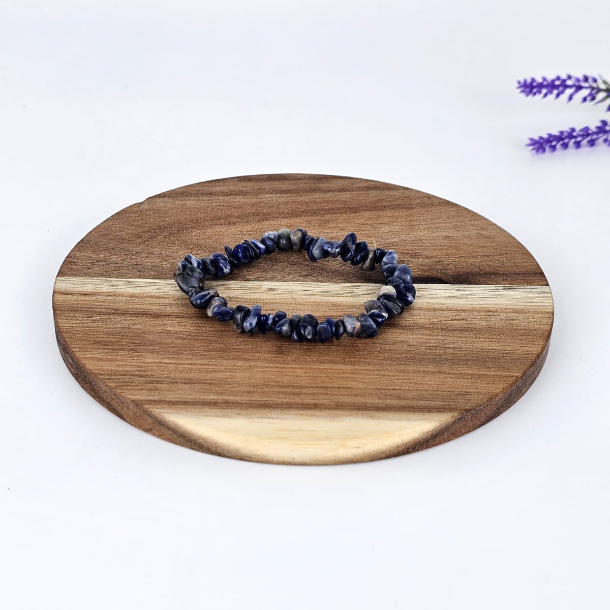 Sodalite chip bracelet on a wooden plate and a white background
