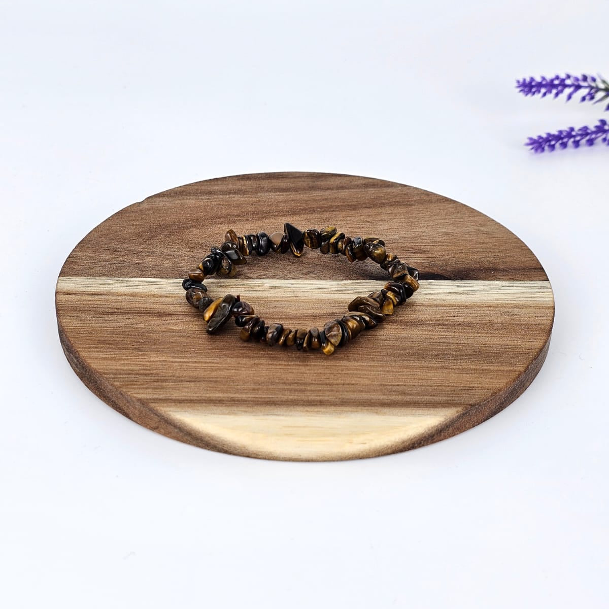 Tiger's eye chip bracelet on a wooden plate and a white background